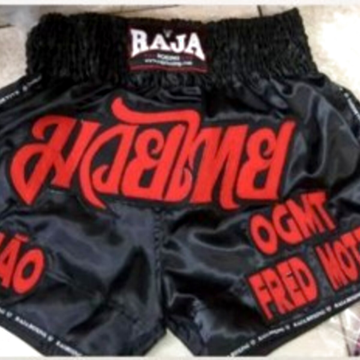 RAJA custom Muay Thai shorts — black & red, OGMT Fred Motta team set